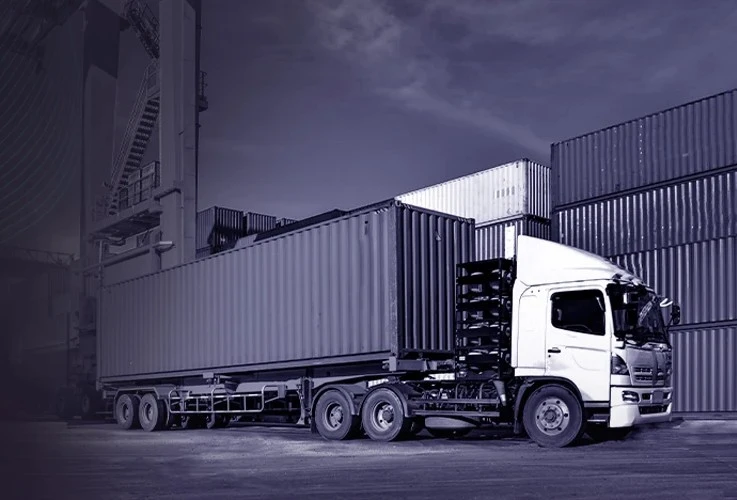 Container truck parked at a shipping yard with stacked cargo containers, representing logistics software designed to build scalable 3PL solutions that handle complex workflows and diverse customer needs.