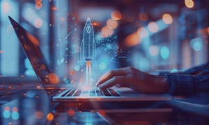 Person working on laptop with digital rocket launch symbol, representing software development services for startups.