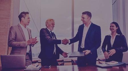 Close-up of business professionals shaking hands, symbolizing commitment and reliability in client partnerships.