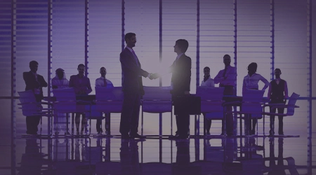 Two business professionals shaking hands over a city skyline, symbolizing trust, integrity, and reliability in partnerships and collaborations.